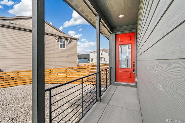 view of exterior entry with a residential view and a balcony