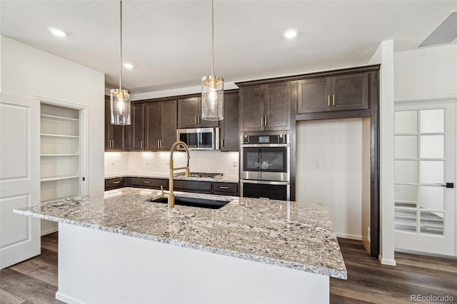 kitchen with appliances with stainless steel finishes, dark wood-style flooring, dark brown cabinetry, and a sink