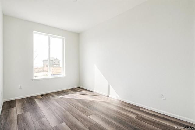 unfurnished room with wood finished floors and baseboards