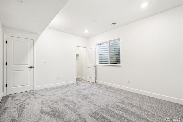 empty room with carpet, visible vents, baseboards, and recessed lighting