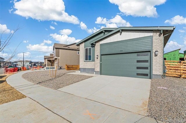 view of front of house featuring an attached garage, brick siding, board and batten siding, and concrete driveway