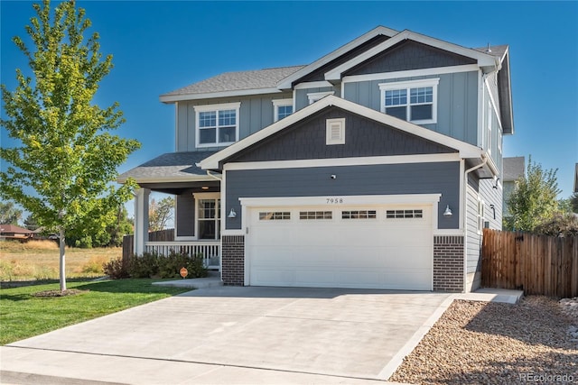 craftsman inspired home featuring a garage, a front lawn, and covered porch