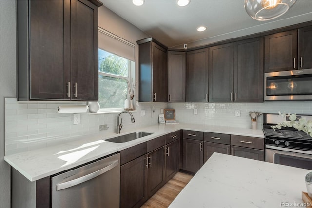 7958 Tejon St, Denver, CO 80221 - kitchen with appliances with stainless steel finishes, a sink, dark brown cabinetry, backsplash, and recessed lighting