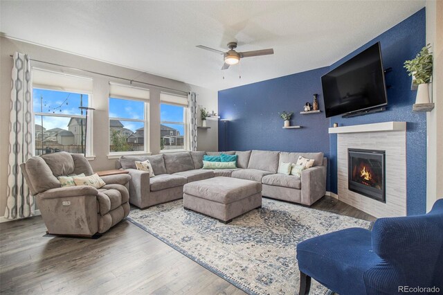 living room with ceiling fan, wood finished floors, and a healthy amount of sunlight