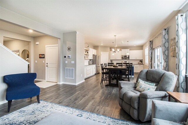 living room with visible vents, dark wood finished floors, baseboards, an inviting chandelier, and recessed lighting
