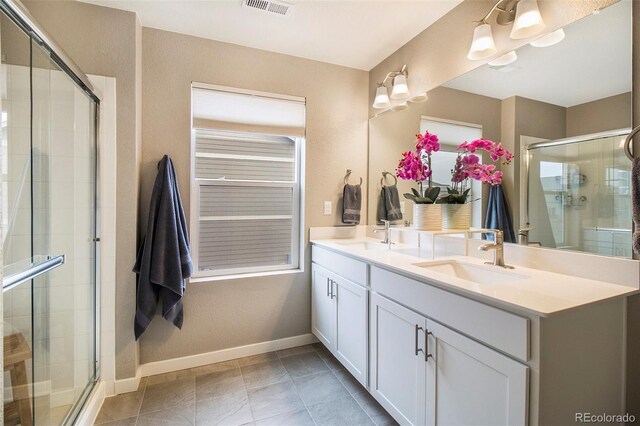 bathroom featuring double vanity, a sink, baseboards, and a shower stall