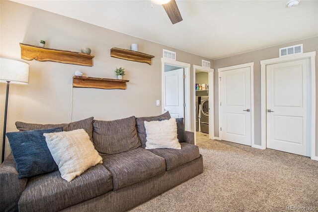 carpeted living room with washer / dryer, a ceiling fan, and visible vents