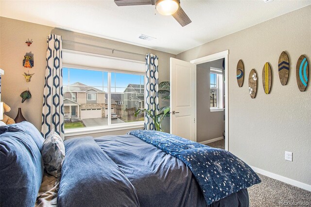 carpeted bedroom with baseboards, visible vents, and ceiling fan