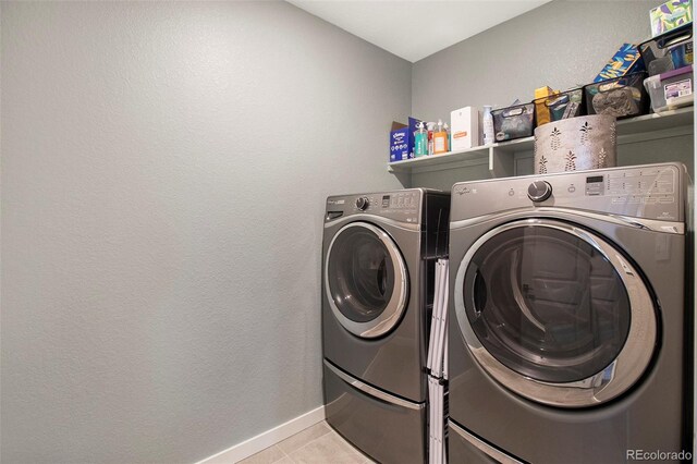 washroom featuring baseboards, laundry area, washing machine and dryer, and light tile patterned floors