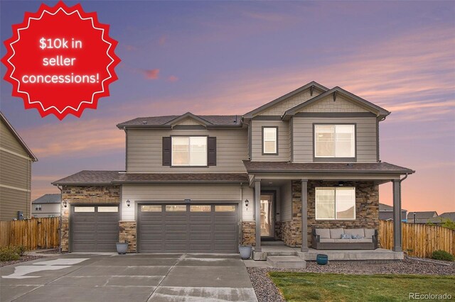 craftsman inspired home featuring covered porch, fence, and concrete driveway