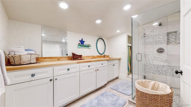 10990 Oehlman Ave, Conifer, CO 80433 - bathroom featuring double vanity, a shower stall, recessed lighting, and wood finished floors