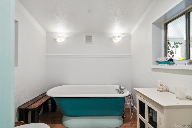 10990 Oehlman Ave, Conifer, CO 80433 - full bathroom featuring a freestanding tub, wood finished floors, and a textured ceiling