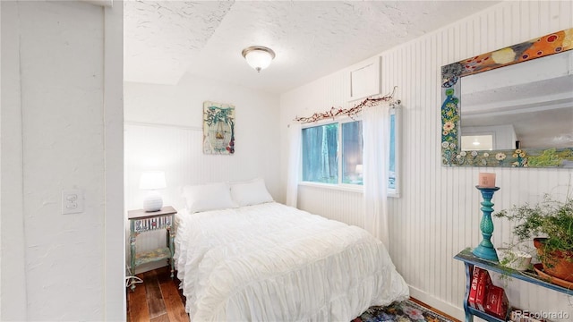 10990 Oehlman Ave, Conifer, CO 80433 - bedroom with wood finished floors and a textured ceiling