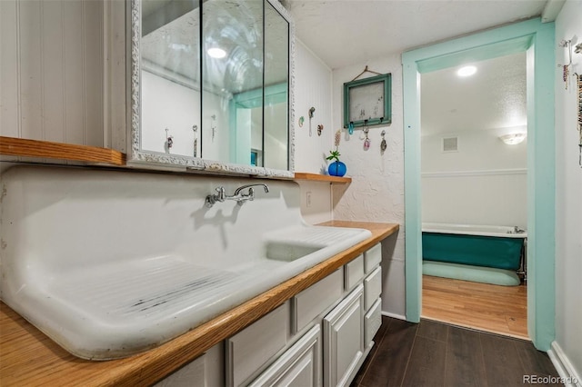 10990 Oehlman Ave, Conifer, CO 80433 - bathroom featuring wood finished floors, vanity, a tub to relax in, and a shower
