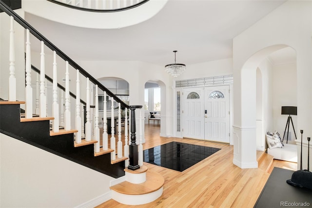 entryway with wood-type flooring and an inviting chandelier