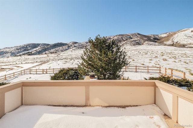 snow covered back of property featuring a mountain view