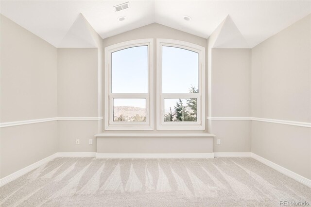 empty room featuring lofted ceiling and carpet floors