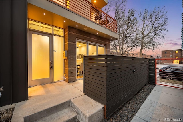 patio terrace at dusk featuring a balcony