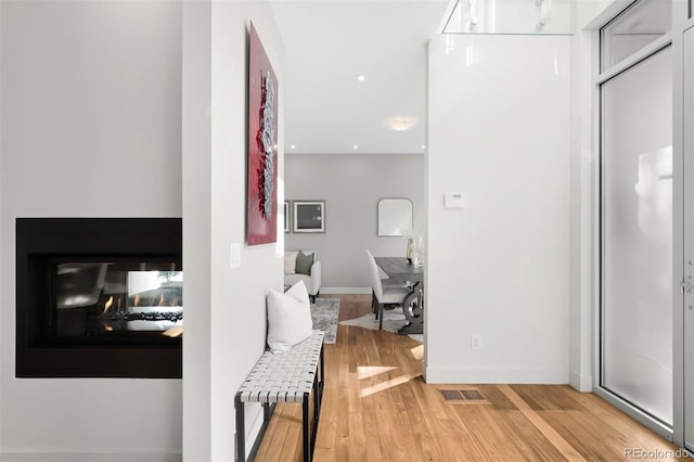 hallway with baseboards, recessed lighting, visible vents, and light wood-style floors