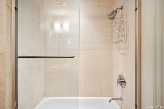 bathroom with bath / shower combo with glass door