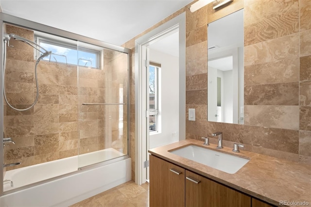 full bath with backsplash, tile patterned flooring, combined bath / shower with glass door, vanity, and tile walls