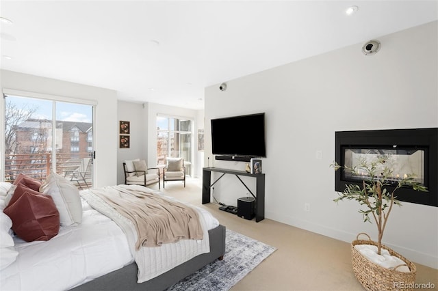 bedroom with carpet floors, recessed lighting, a glass covered fireplace, access to outside, and baseboards