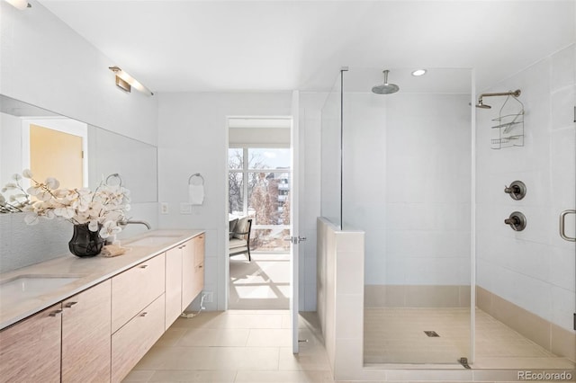 full bathroom featuring double vanity, a sink, a shower stall, and tile patterned floors