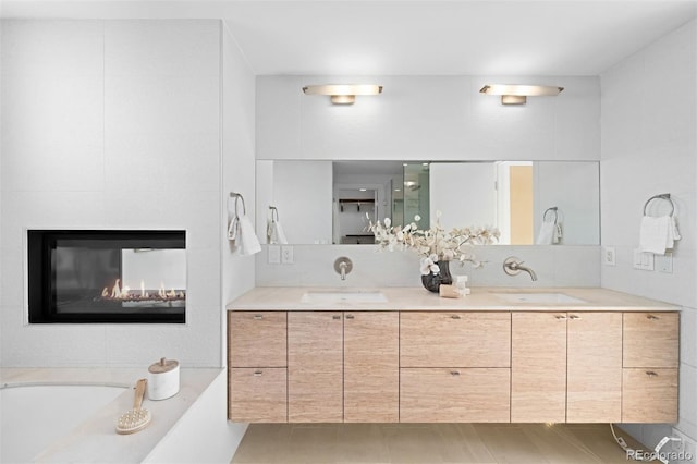 full bath with a garden tub, double vanity, a sink, and a multi sided fireplace