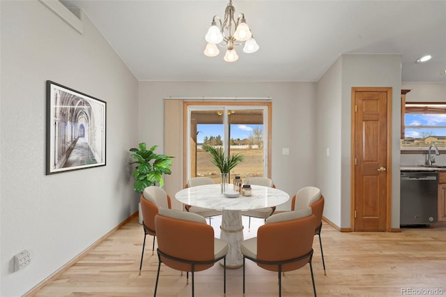 dining area featuring baseboards, a notable chandelier, light wood-type flooring, and plenty of natural light