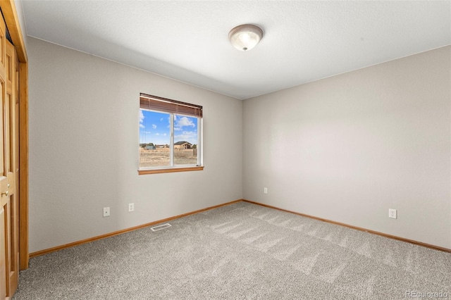 unfurnished room with light colored carpet, visible vents, and baseboards
