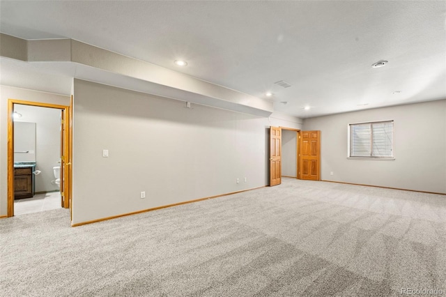 unfurnished room featuring light carpet, baseboards, and recessed lighting