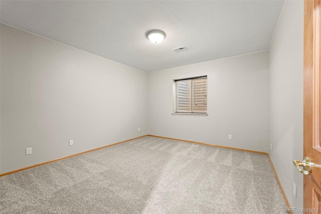 empty room with baseboards, visible vents, and carpet