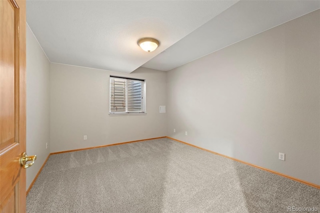 carpeted empty room featuring baseboards