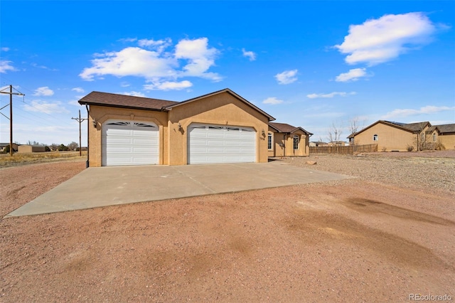 view of front of property featuring stucco siding, an attached garage, and concrete driveway