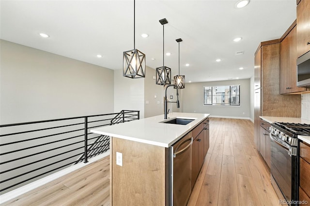 2074 S Holly St Unit 2, Denver, CO 80222 - kitchen featuring appliances with stainless steel finishes, light wood finished floors, recessed lighting, a center island with sink, and light countertops