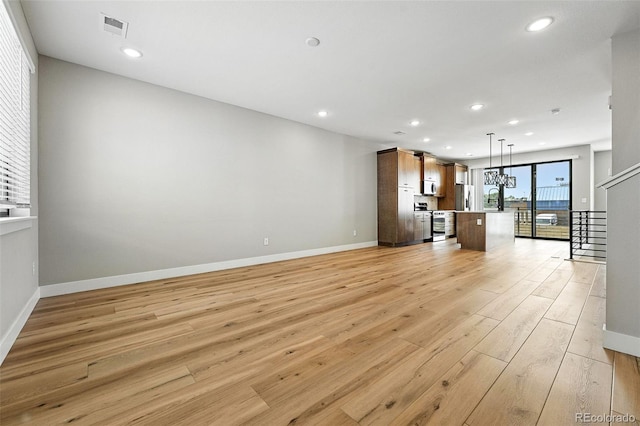 2074 S Holly St Unit 2, Denver, CO 80222 - unfurnished living room featuring light wood-style flooring and recessed lighting