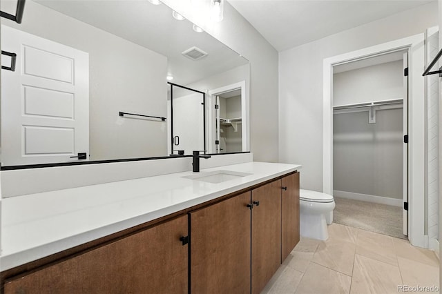 2074 S Holly St Unit 2, Denver, CO 80222 - bathroom with a spacious closet, vanity, a shower stall, and tile patterned floors