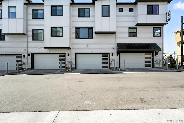 2074 S Holly St Unit 2, Denver, CO 80222 - view of front of home featuring a standing seam roof, a garage, and a metal roof