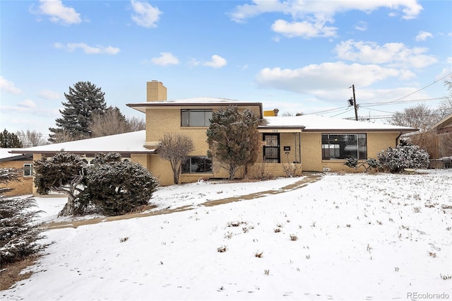 view of snow covered back of property