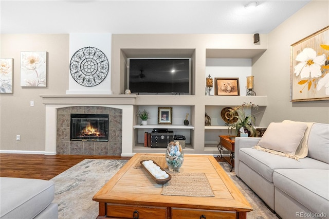 9631 S Dover Way, Littleton, CO 80127 - living room with wood finished floors, a tile fireplace, built in shelves, and baseboards