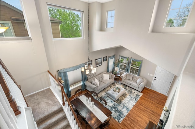 9631 S Dover Way, Littleton, CO 80127 - living room featuring a chandelier, baseboards, wood finished floors, and a high ceiling