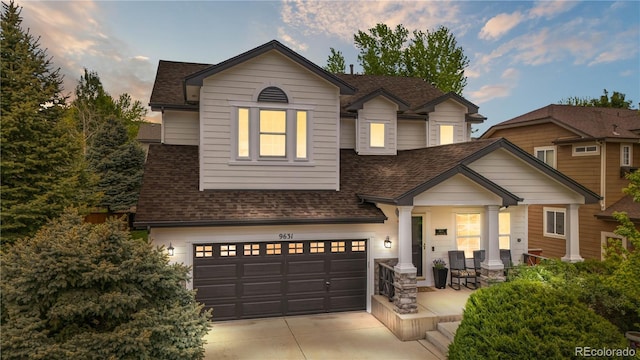 9631 S Dover Way, Littleton, CO 80127 - view of front of house featuring roof with shingles, a garage, concrete driveway, and covered porch