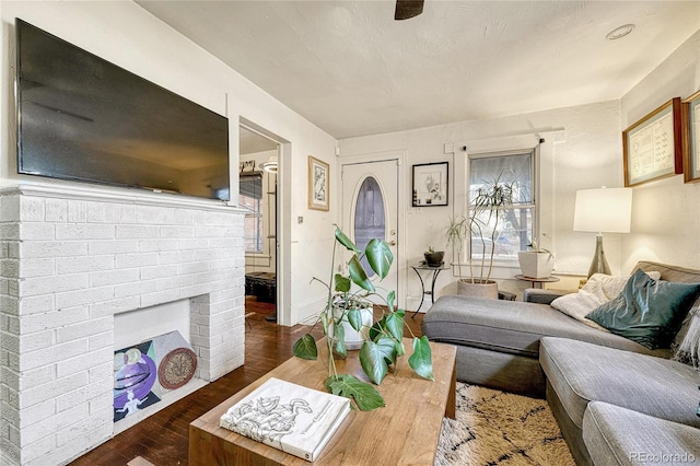 living room with dark hardwood / wood-style floors and a brick fireplace