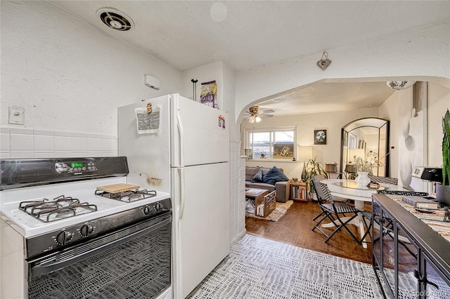 kitchen featuring light tile patterned floors, white appliances, and ceiling fan