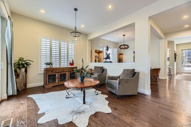 living room featuring a chandelier, plenty of natural light, and dark wood-type flooring