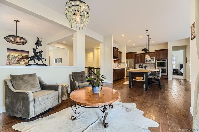 14969 Elsinore Ave, Parker, CO 80134 - living room featuring a chandelier, dark wood-type flooring, and baseboards