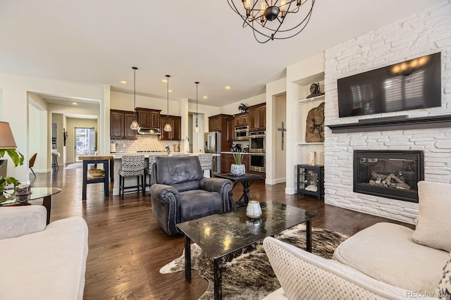 14969 Elsinore Ave, Parker, CO 80134 - living area with dark wood-style floors, a chandelier, a fireplace, baseboards, and recessed lighting