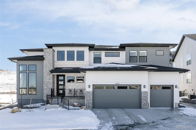 prairie-style house featuring cooling unit and a garage