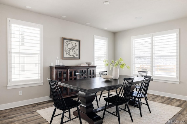 dining space with a wealth of natural light and dark wood-type flooring