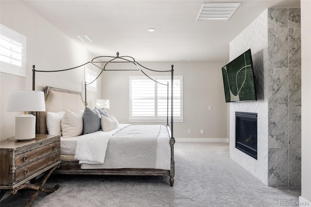 bedroom with multiple windows, a fireplace, and carpet